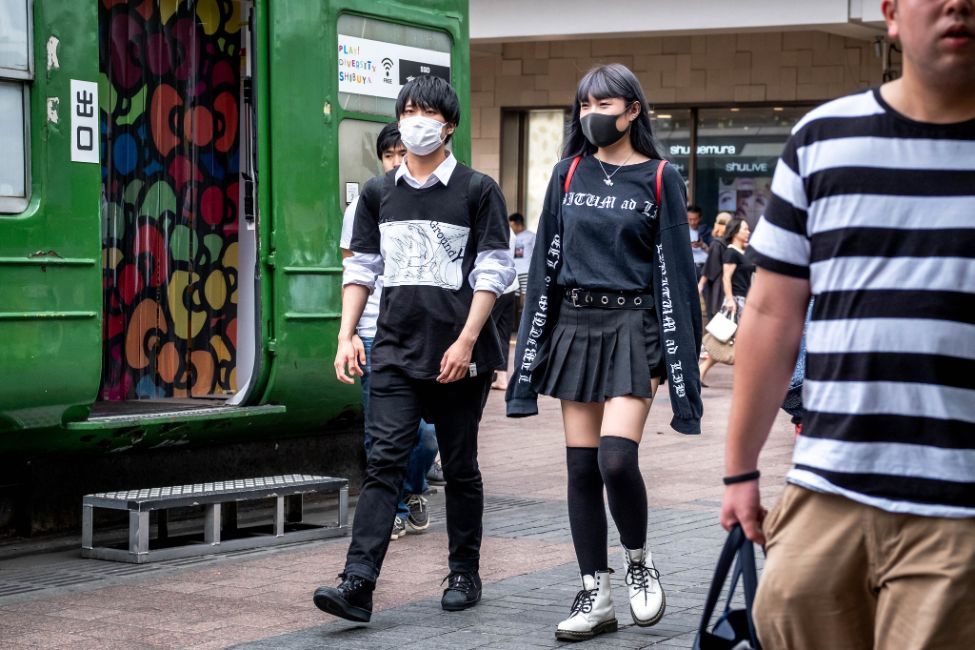 To unge japanere, en mann og en kvinne går med munnbind i Tokyo