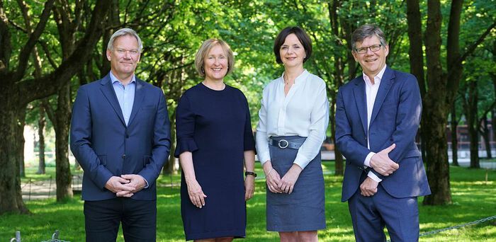 To menn og to kvinner står i en allé på Blindern