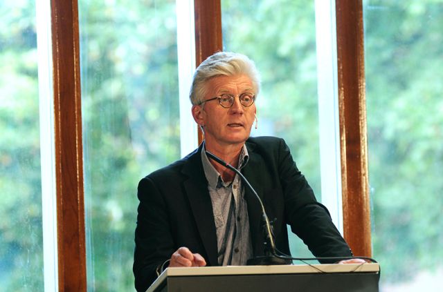 En mann med briller står på en talerstol
