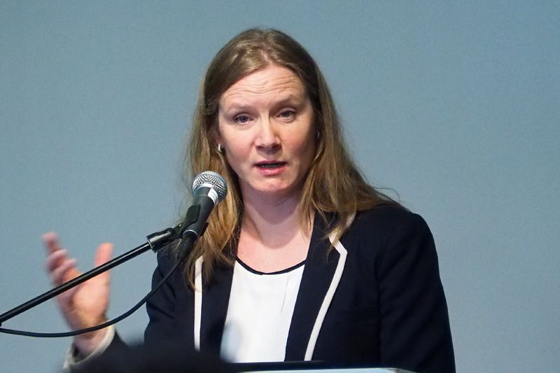En kvinne står på en talerstol med en mikrofon foran seg