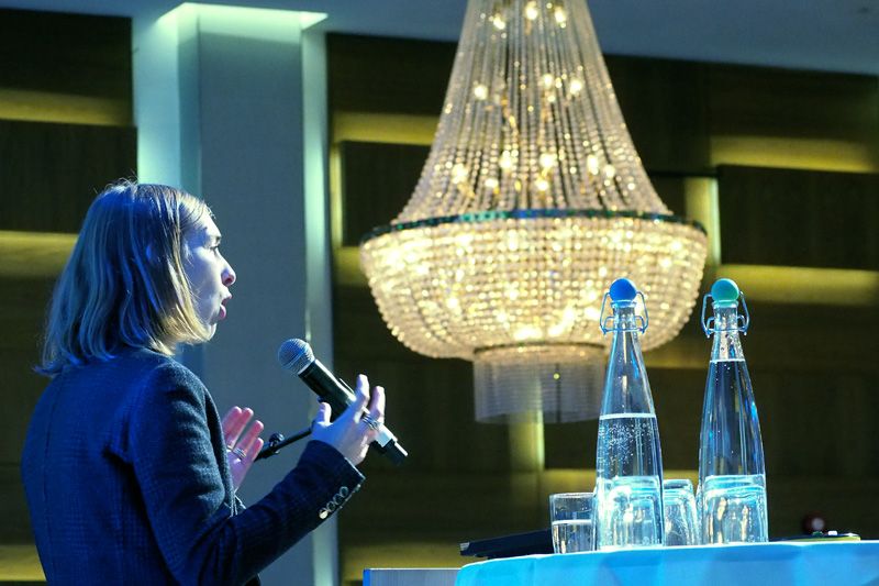 Forsknings- og høyere utdanningsminister Iselin Nybø står på talerstolen foran en stor lysekrone i Radisson Blue hotell i Oslo.