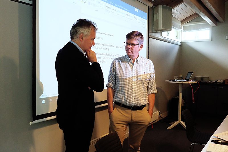 To menn står framfor ein skjerm med Power Point-presentasjon