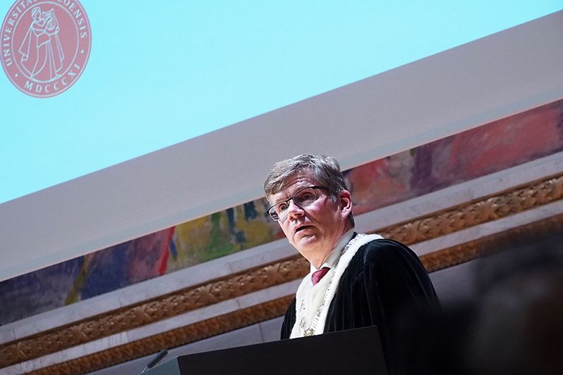 Rektor Svein Stølen står på talerstolen i Universitetets aula