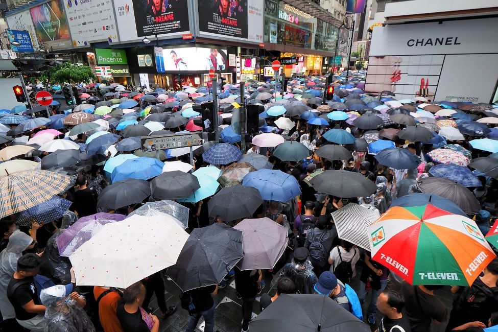Folk demonstrerer under paraplyar i Hongkong