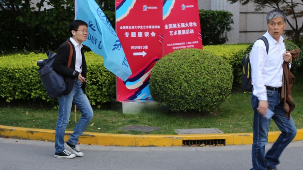 To mannlige studenter spaserer over campus ved Fudan University, Kina