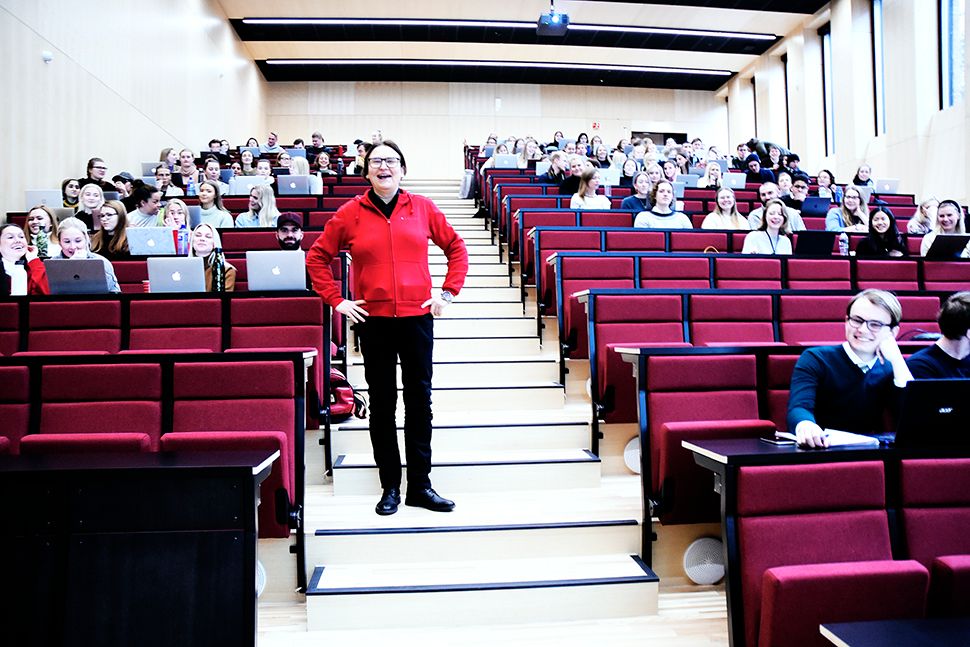 Dekan Raghild Hennum står i midtgangen i et stort auditorium, halvfullt med studenter