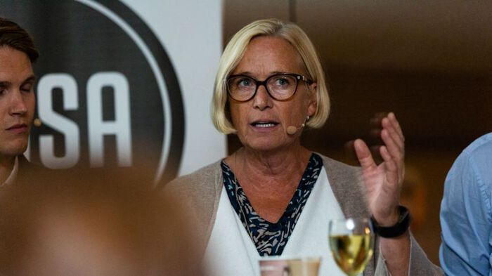 Ei kvinne ser rett fram mens hun deltar i en debatt