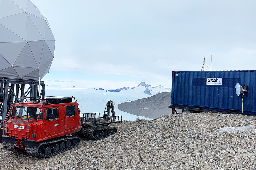 En beltebil og en forskningsstasjon i Antarktis