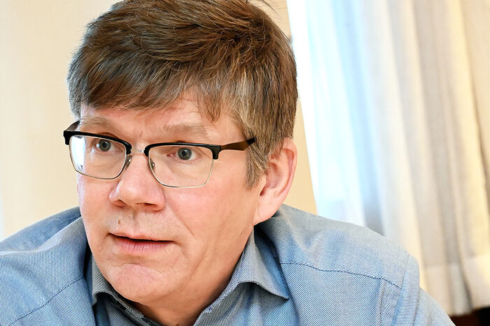 Eit portrett av ein mann med briller og blå skjorte