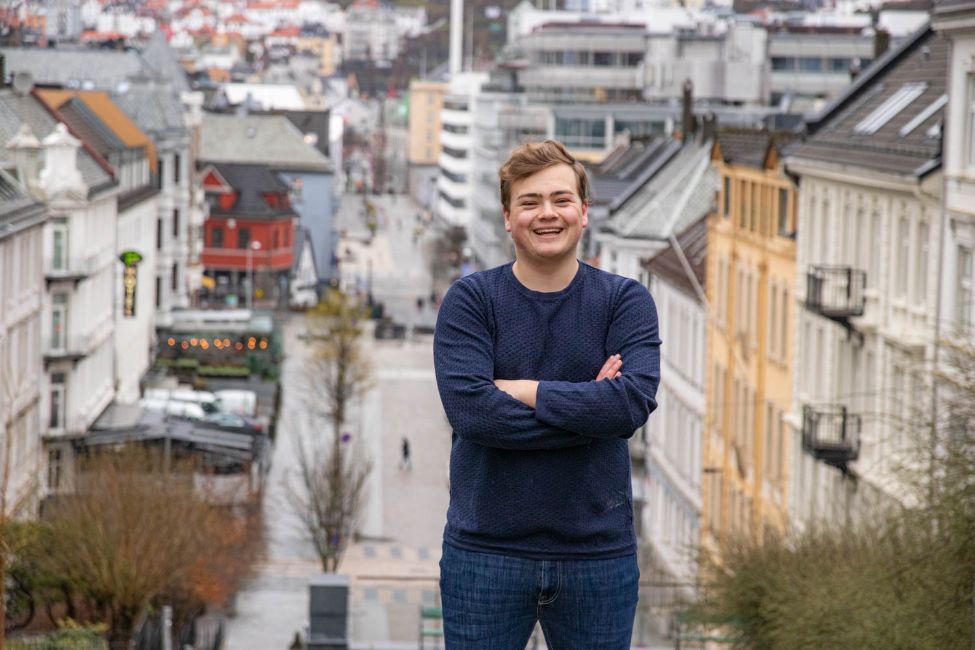 Ein mann står med Bergen sentrum i bakgrunnen