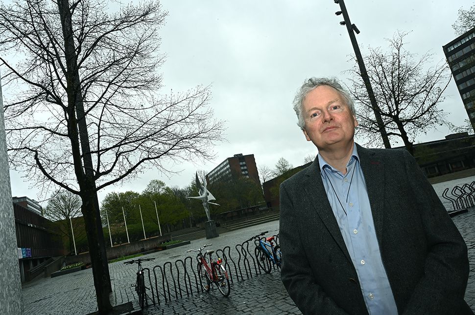 Ein mann står på Frederikkplassen med bygningane bak seg