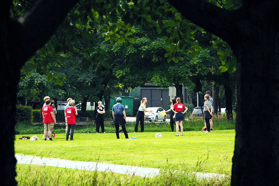 Ein gjeng med studentar står på ein grøn grasplen