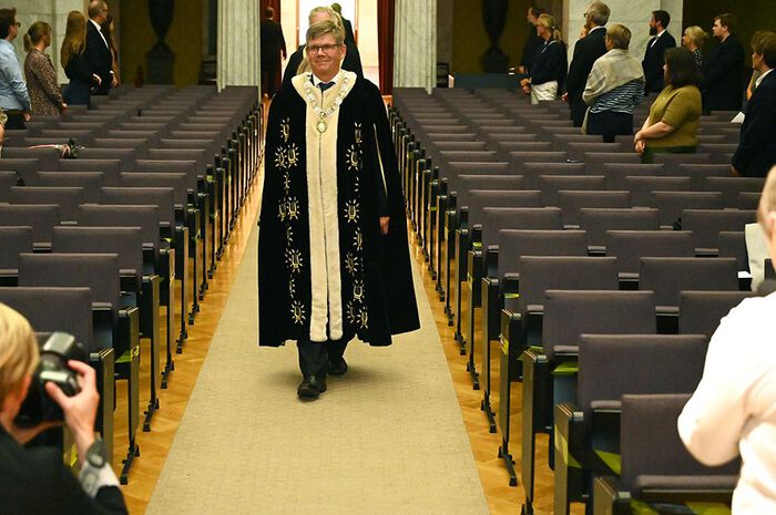 En mann går i midtgangen i Universitetets aula