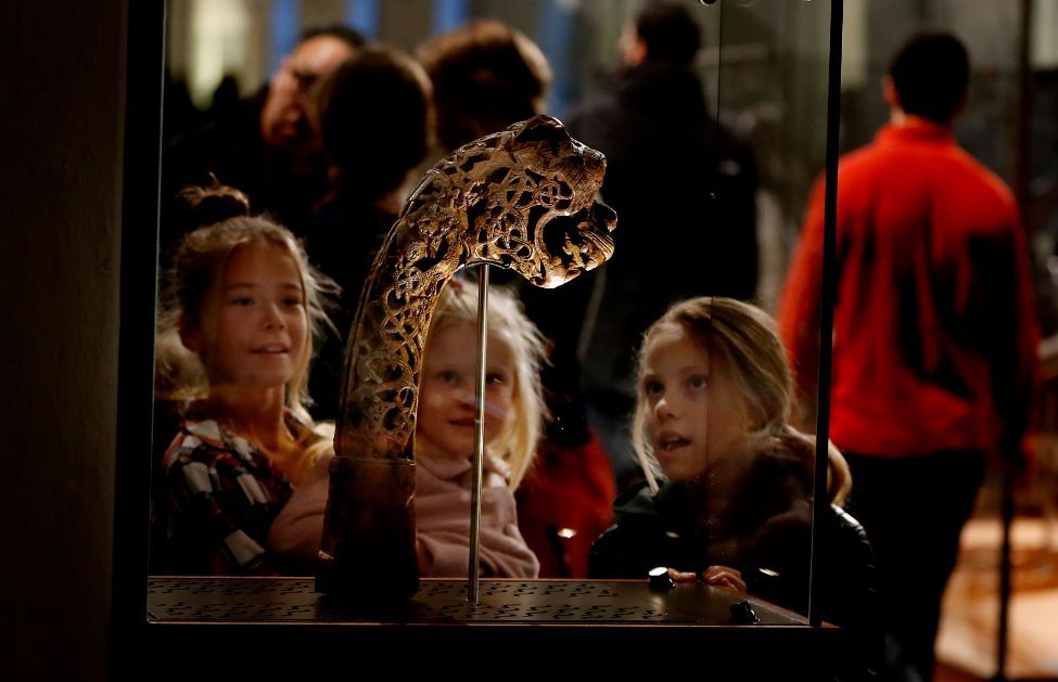 Barn betrakter en gjenstand i en vikingutstilling på Kulturhistorisk museum