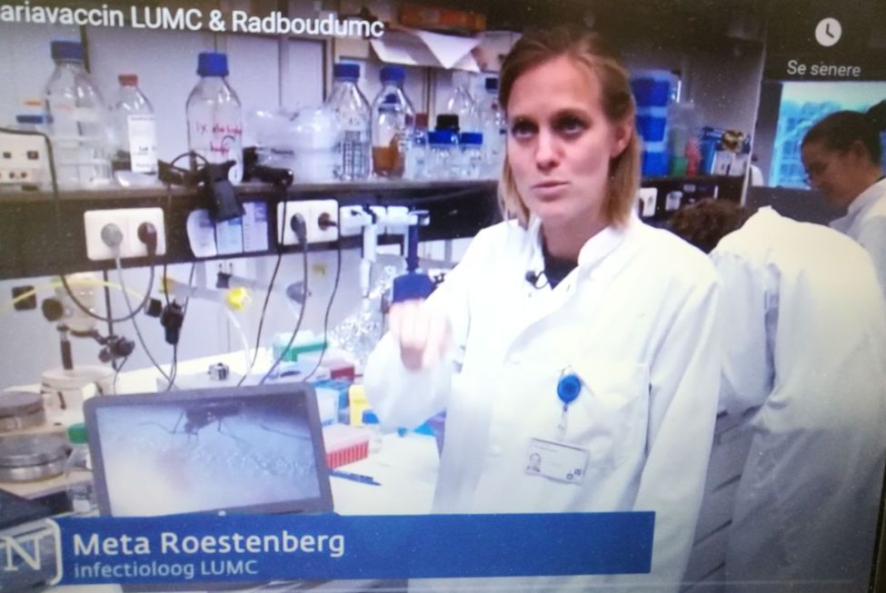 En kvinne med hvit frakk står i et laboratorium
