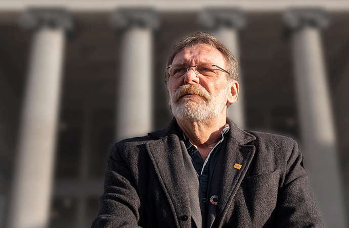 Portrett av en mann med briller og skjegg utenfor Universitetets aula