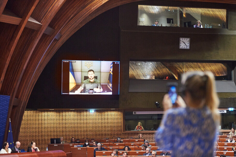 En mann fra en skjerm snakker til EU-parlamentet