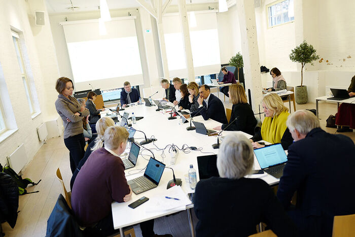 Mange personar sit rundt eit bort