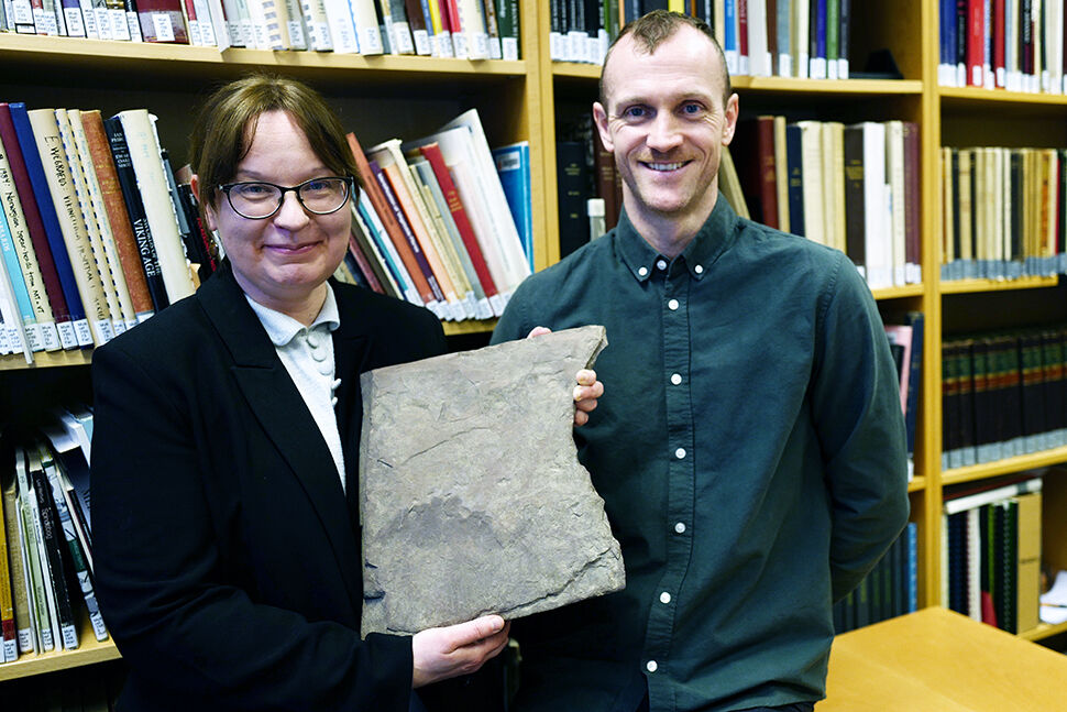 Ei kvinne og ein mann viser fram verdas eldste runestein