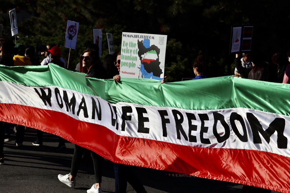 Et stort banner med teksten woman, life, freedom i  protest mot Irans regime