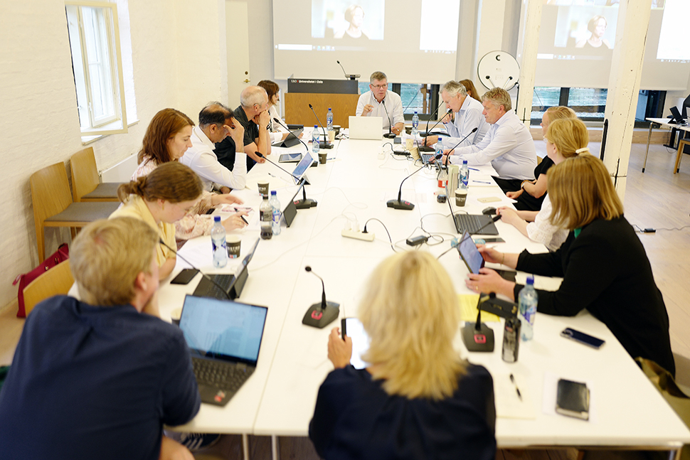 Fleire personar sit rundt eit langbord