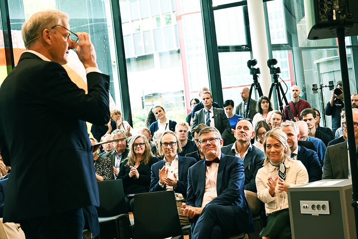 Ein mann held innlegg på ei pressekonferanse